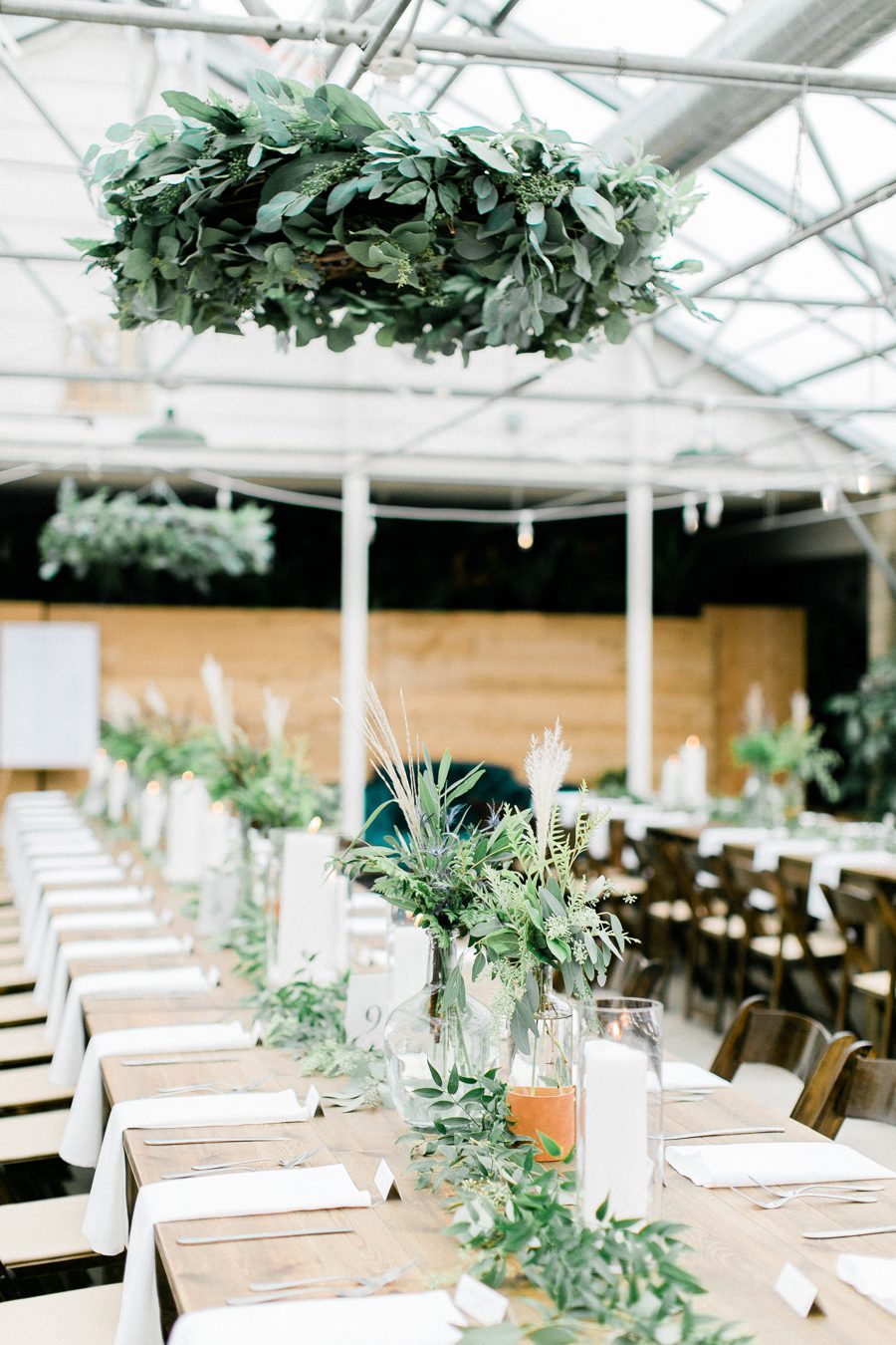 modern greenhouse wedding photos, carly mccray photography, lake geneva wedding photographer, madison wedding photographers, modern greenery wedding, modern wisconsin greenhouse wedding, modern greenery wedding, sleek wedding dress, greenery boutonnieres, black taper candles, green florals, modern greens