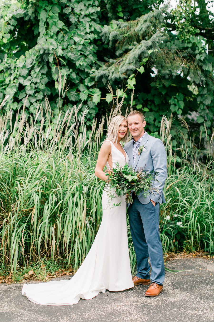 modern greenhouse wedding photos, carly mccray photography, lake geneva wedding photographer, madison wedding photographers, modern greenery wedding, modern wisconsin greenhouse wedding, modern greenery wedding, sleek wedding dress, greenery boutonnieres, black taper candles, green florals, modern greens