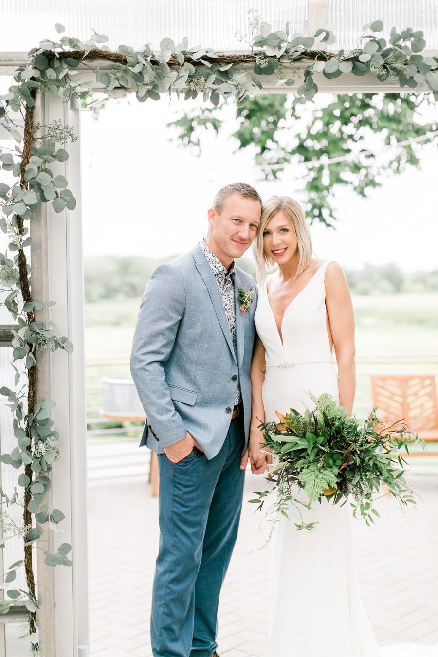 modern greenhouse wedding photos, carly mccray photography, lake geneva wedding photographer, madison wedding photographers, modern greenery wedding, modern wisconsin greenhouse wedding, modern greenery wedding, sleek wedding dress, greenery boutonnieres, black taper candles, green florals, modern greens