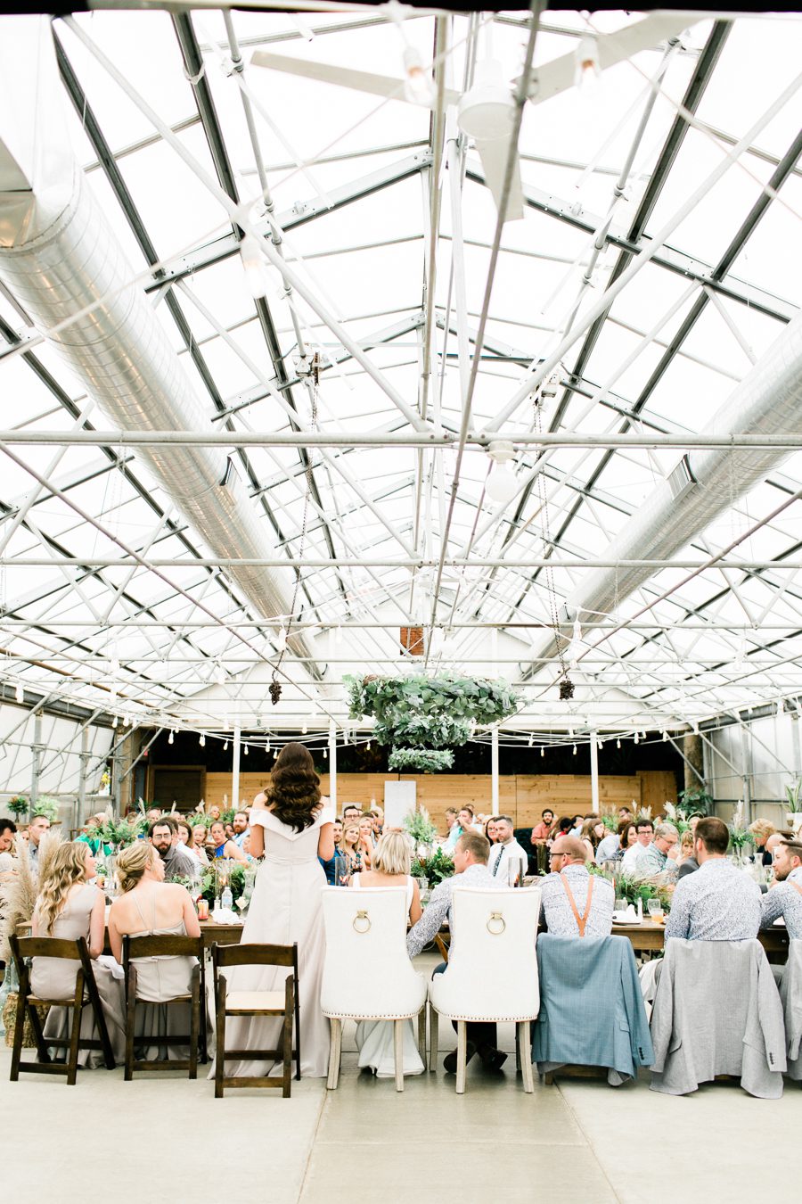 modern greenhouse wedding photos, carly mccray photography, lake geneva wedding photographer, madison wedding photographers, modern greenery wedding, modern wisconsin greenhouse wedding, modern greenery wedding, sleek wedding dress, greenery boutonnieres, black taper candles, green florals, modern greens